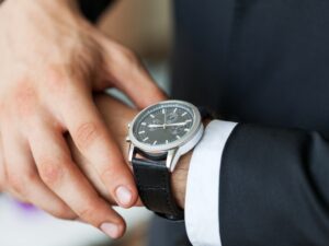 businessman-pointing-hand-watch-grey-wall-background-close-up.jpg