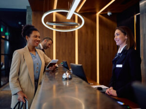 happy-black-businesswoman-checking-hotel-reception-desk.jpg