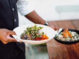 midsection-waiter-serving-two-dishes-wooden-table.jpg